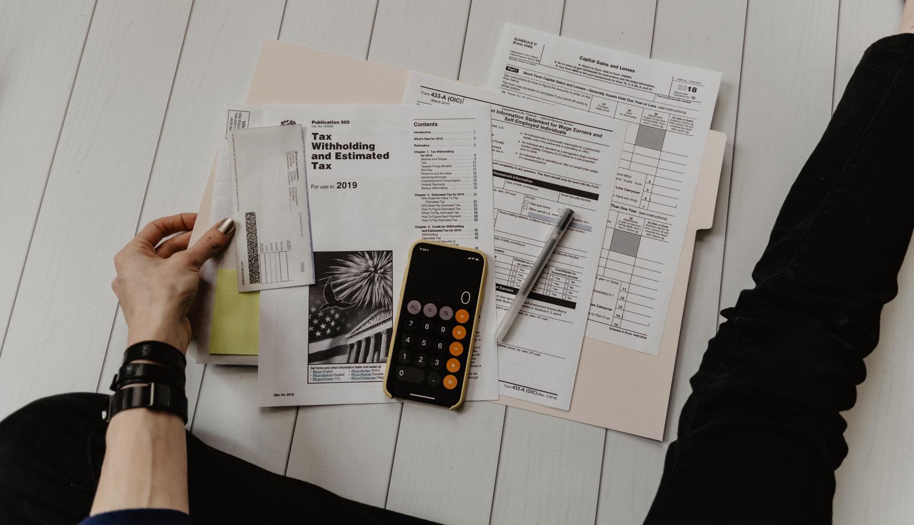 accounts receivable paperwork and smart phone out on a wooden table